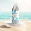 Veena Ocean Breeze Premium Vaporizer and Diffuser Oil 100ml canister resting on an elegant white podium with clear crashing ocean waves background.