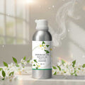 Veena Jasmine Vaporizer and Diffuser Oil 100ml bottle with delicate white jasmine blossoms and soft lighting in the background.