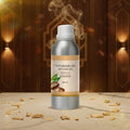 Veena Sandalwood Vaporizer and Diffuser Oil 100ml bottle displayed on a clean marble slab with sandalwood chips and upscale warm interior lighting.