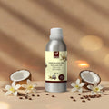 Veena Coco Vanilla Premium Vaporizer and Diffuser Oil 100ml aluminum bottle flanked by opened coconut halves and vanilla orchid flowers.