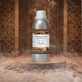 Veena Oudh Vaporizer and Diffuser Oil 100ml bottle centered in front of a luxury, traditional carved wooden backdrop with aromatic smoke.