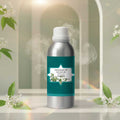 Veena Camphor Vaporizer and Diffuser Oil 100ml bottle surrounded by elegant white flowers and aromatic smoke in a serene architectural setting.