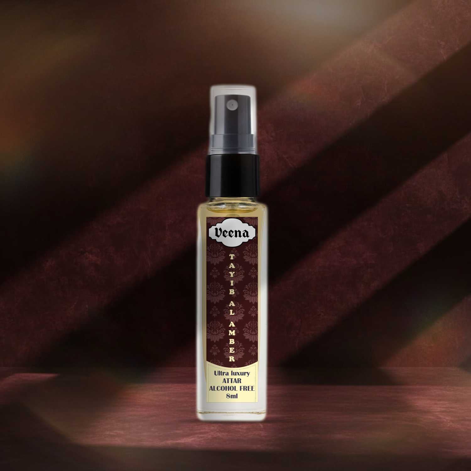 Veena Tayib Al Amber traditional rich balsamic perfume spray bottle highlighted on a deep burgundy textured background.