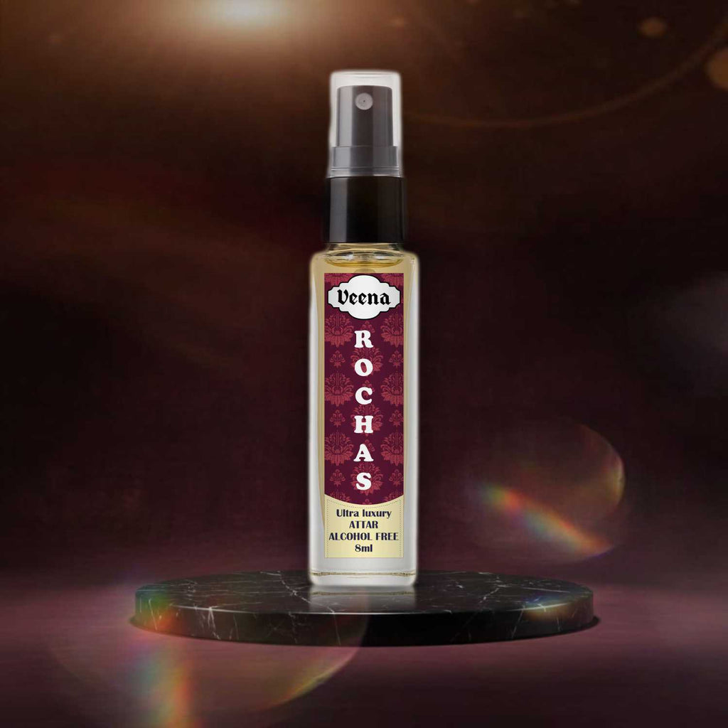 Veena Rochas ultra-luxury non-alcoholic 8ml attar spray bottle displayed centered on a polished dark green marble disk pedestal with cinematic rainbow light leaks against a rich dark maroon studio background.
