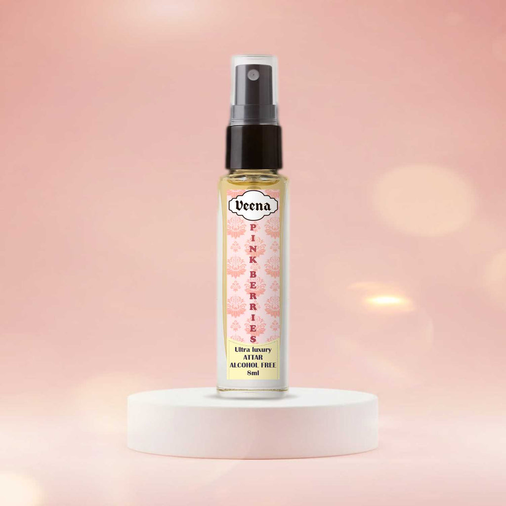 Veena Pink Berries luxury fine-mist 8ml attar spray vial standing gracefully on a minimalist matte white circular block podium with a soft pastel pink bokeh light background.