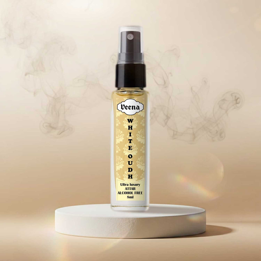 Veena White Oudh premium 8ml travel spray bottle showcased under dramatic studio spotlights on a white round stone pedestal with elegant swirling smoke plumes behind.