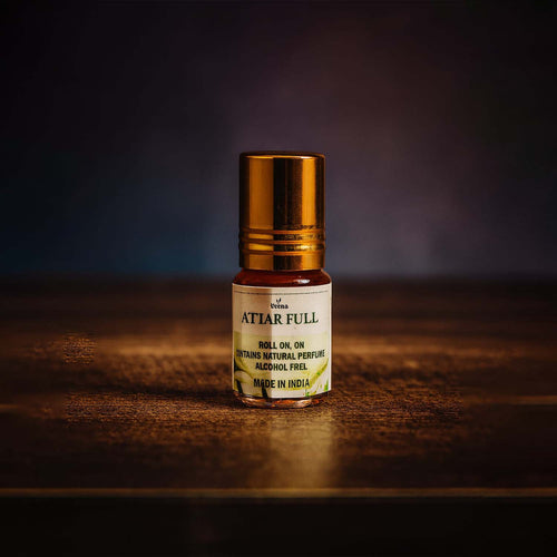 Veena luxury non-alcoholic Attar Full jasmine perfume oil roll-on bottle highlighted on a rich dark textured studio surface.
