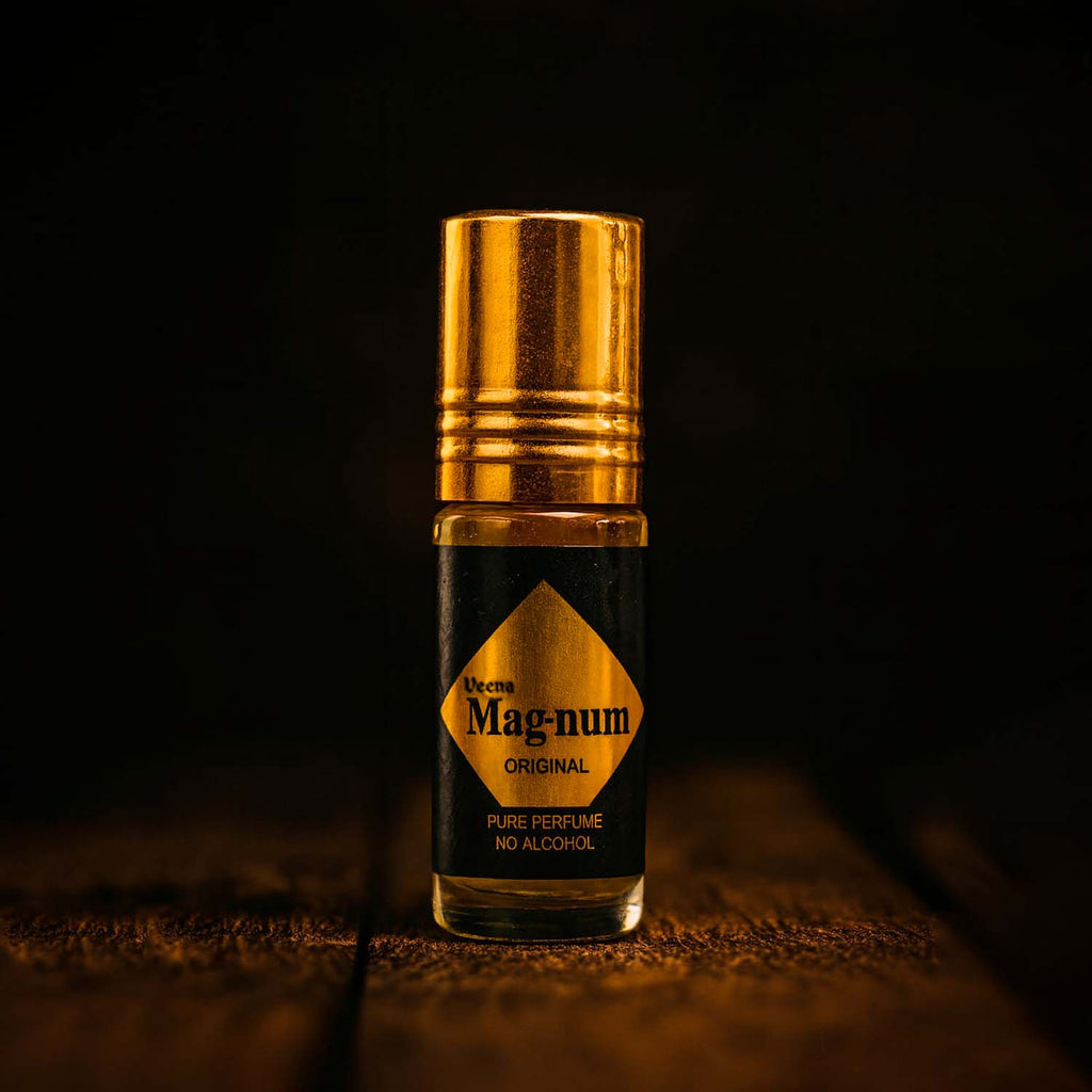 Veena Magnum Series Original pure perfume pocket-sized roll-on bottle with an opulent gold cap displayed under rich cinematic spotlighting.