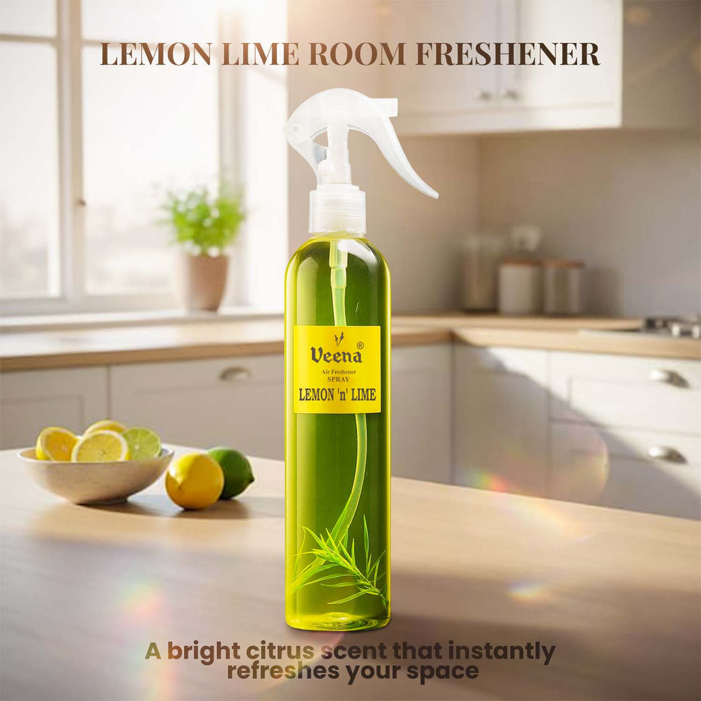 Veena Lemon n Lime premium room freshener spray bottle displayed on a wooden counter with fresh lemons and limes in a kitchen setting.