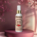 Veena Rose Oudh premium attar spray 100ml bottle with a gold collar displayed on a luxury mauve round podium with soft floral backgrounds.