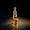 Veena Royal Series Amber Magique pure perfume concentrate bottle highlighted under luxury golden cinematic lighting.