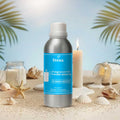 Veena Summer Breeze Fragrance for Candle Making aluminum bottle on a beach sand display background surrounded by sea shells, star fish, and burning white candles.