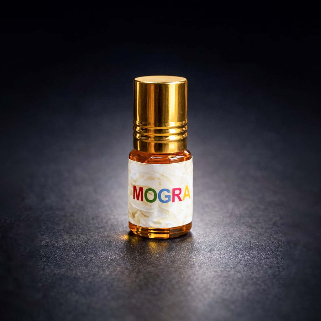 Veena luxury non-alcoholic Mogra jasmine perfume oil bottle highlighted on a rich dark textured studio surface.