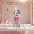 Veena English Rose Floor Mopping Fragrance 500g aluminum bottle displayed with a pink mop and bucket inside a clean tiled bathroom setting.