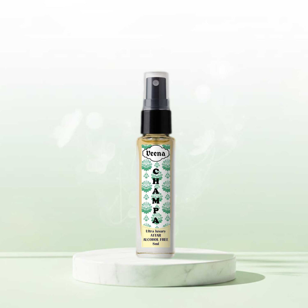 Veena Champa premium non-alcoholic floral attar spray bottle displayed elegantly on a white marble pedestal against a soft green background.