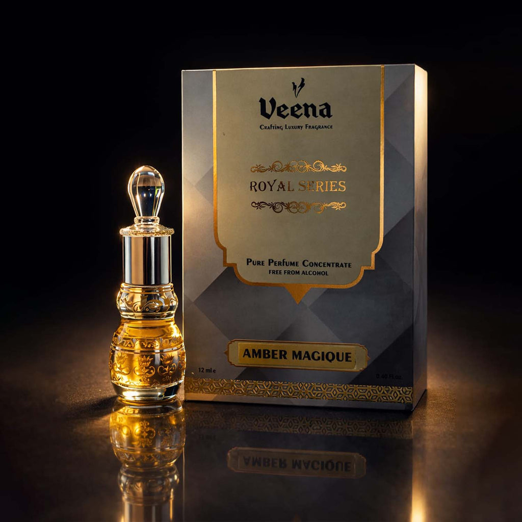 Veena Amber Magique luxury non-alcoholic perfume oil decanter standing elegantly next to its gold and gray presentation box.