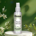 Veena Phool Mogra alcohol-free attar spray 100ml bottle on a stone terrazzo podium surrounded by fresh white jasmine blossoms.