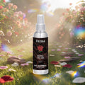Veena Rose Oudh alcohol-free attar spray 100ml bottle standing in a sunny, blooming rose garden with cinematic light flares.