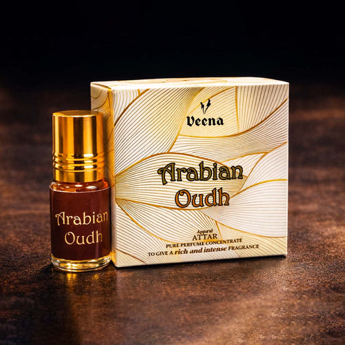 Veena Arabian Oudh premium apparel attar concentrate bottle standing next to its luxury cream and gold golden-wave presentation gift box.