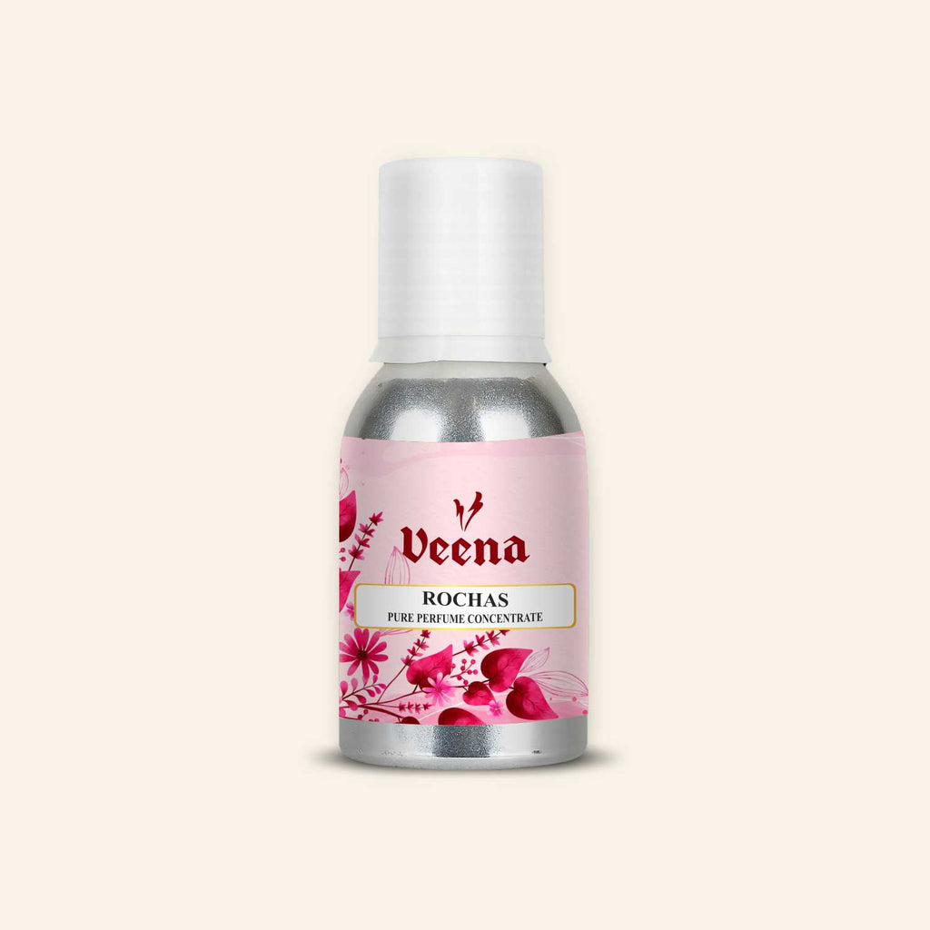 Veena Rochas Pure Perfume Concentrate aluminum bottle with a soft pink background featuring deep pink and magenta floral bouquet illustrations on the label design.