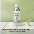 Veena Lemongrass Floor Mopping Fragrance 500g aluminum bottle displayed on a white podium with a green mop and bucket background.