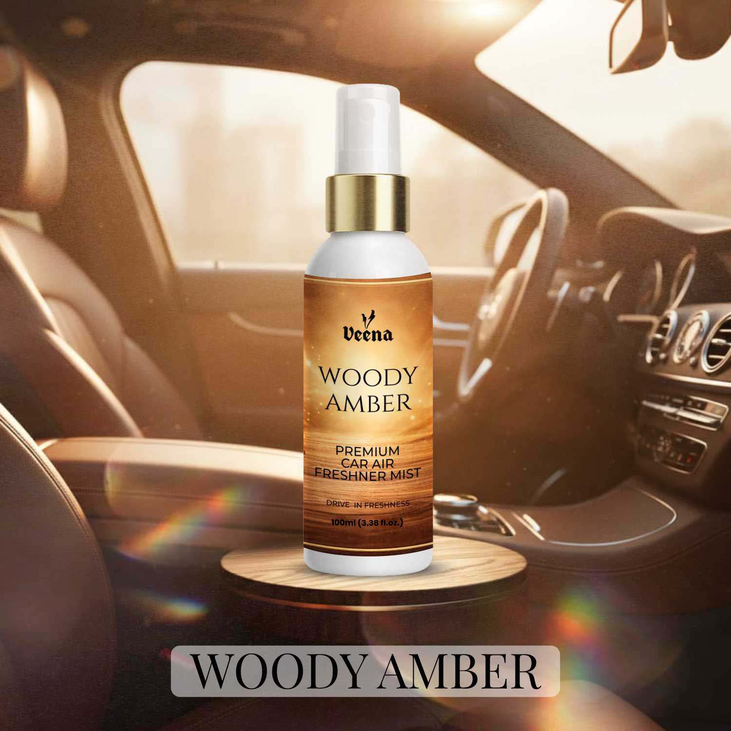 Veena Woody Amber Premium Car Air Freshner Mist 100ml bottle on a wood grain pedestal showcase inside a rich brown leather car interior.