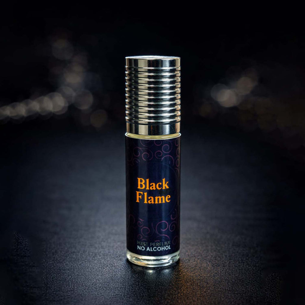 Veena Black Flame premium non-alcoholic perfume oil roll-on bottle with a dark orange spiral print label and ribbed silver cap against a dark bokeh background.