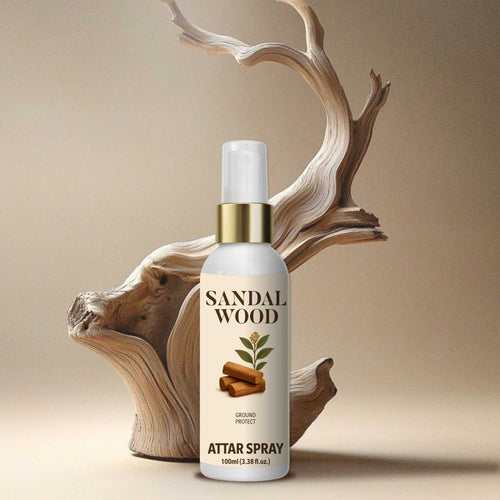 Premium Sandalwood attar spray 100ml bottle with a gold collar displayed elegantly in front of a natural, artistic driftwood sculpture.
