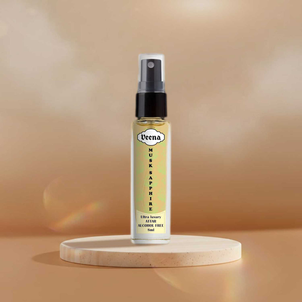 Veena Musk Sapphire fresh non-alcoholic attar mist vial highlighted on a sand-colored stone podium.