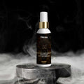 Veena Khatu Shyam Ji Pavitar attar spray 100ml bottle with a gold collar standing on a dark marble pedestal surrounded by dramatic cinematic smoke.