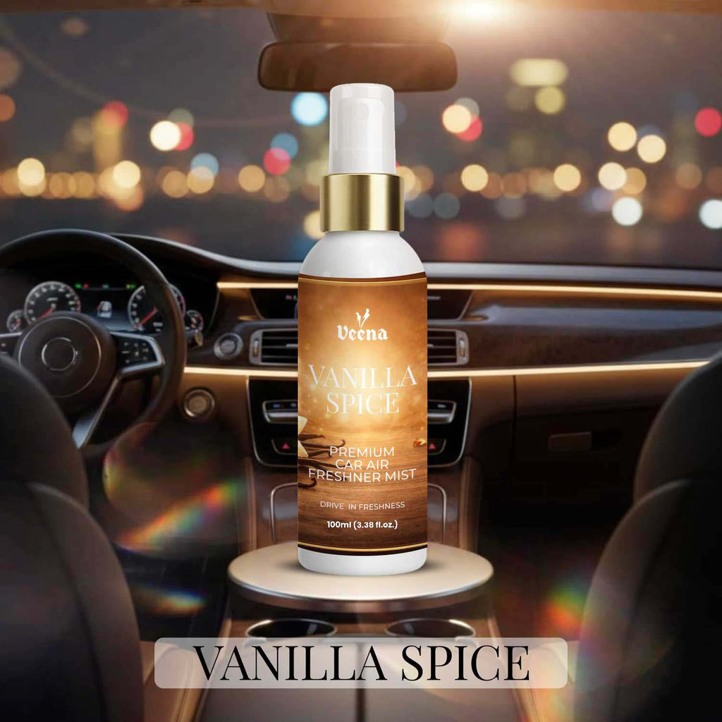 Veena Vanilla Spice Premium Car Air Freshner Mist 100ml bottle positioned inside a car cockpit with warm golden city bokeh lights glowing outside the windshield.