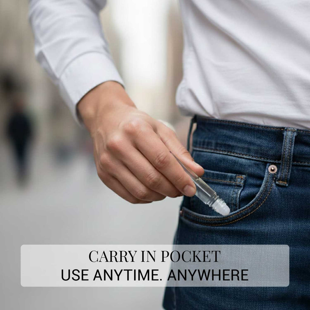 A close-up action shot showing a person slipping a travel-friendly glass attar roll-on bottle into a blue jean pocket.