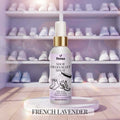 Veena Shoe Deodorant Spray French Lavender 100ml bottle positioned on a white marble platform with a large luxury shoe rack closet blurred in the background.