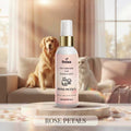 Veena Pet Perfume for Dogs and Cats Rose Petals 100ml spray bottle standing on a luxury marble podium with a Golden Retriever and a white cat resting on a couch in a sunlit living room background.