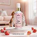 Veena Strawberry Pet Perfume for Dogs and Cats 100ml spray bottle showcased on a white pedestal surrounded by fresh red strawberries, featuring a fluffy cat and Beagle dog background.