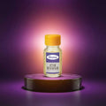 Veena Premium Attar Ruh Kesar 2ml miniature glass bottle standing on luxury marble podium with deep purple backdrop