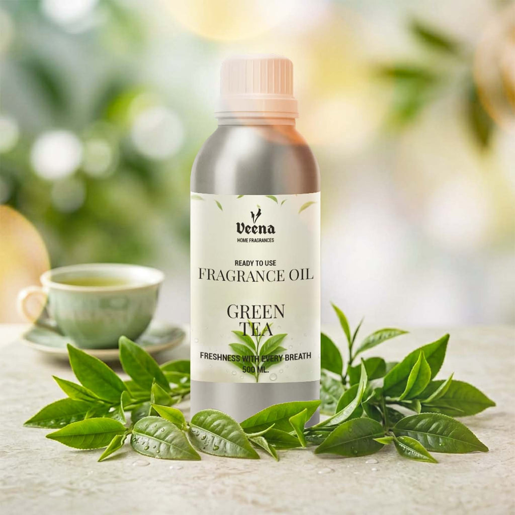 Veena Home Fragrances 500ml Green Tea Fragrance Oil aluminum bottle on a surface surrounded by vibrant fresh green tea leaves with a tea cup background.