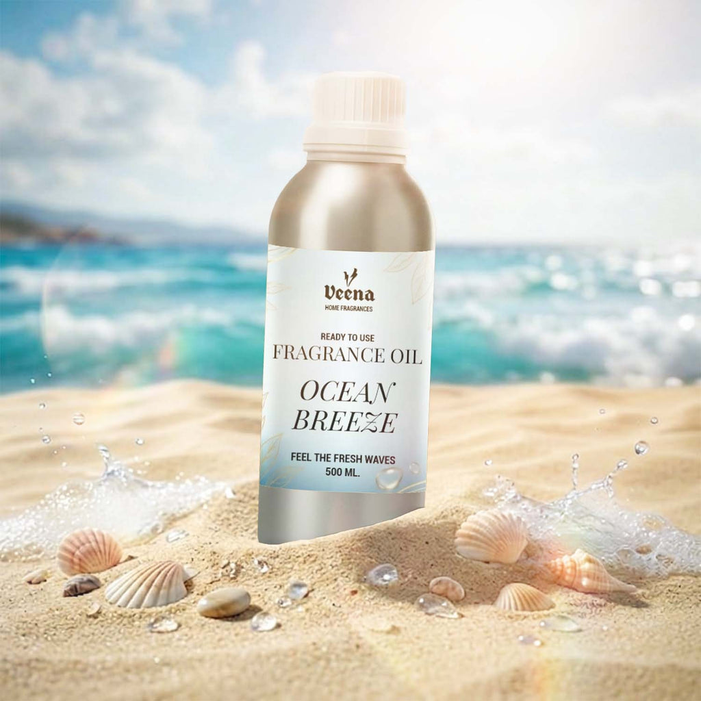 Veena Home Fragrances 500ml Ocean Breeze Fragrance Oil aluminum bottle on a sandy beach surrounded by seashells with ocean waves in the background.