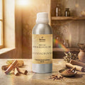 Veena Home Fragrances 500ml Sandalwood Fragrance Oil aluminum bottle on a table surrounded by natural sandalwood logs, wood shavings, and powder.