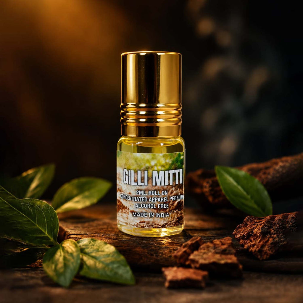 Gilli Mitti 2ml perfume oil roll-on placed over rustic wood logs and fresh green leaves, symbolizing rain on earth.