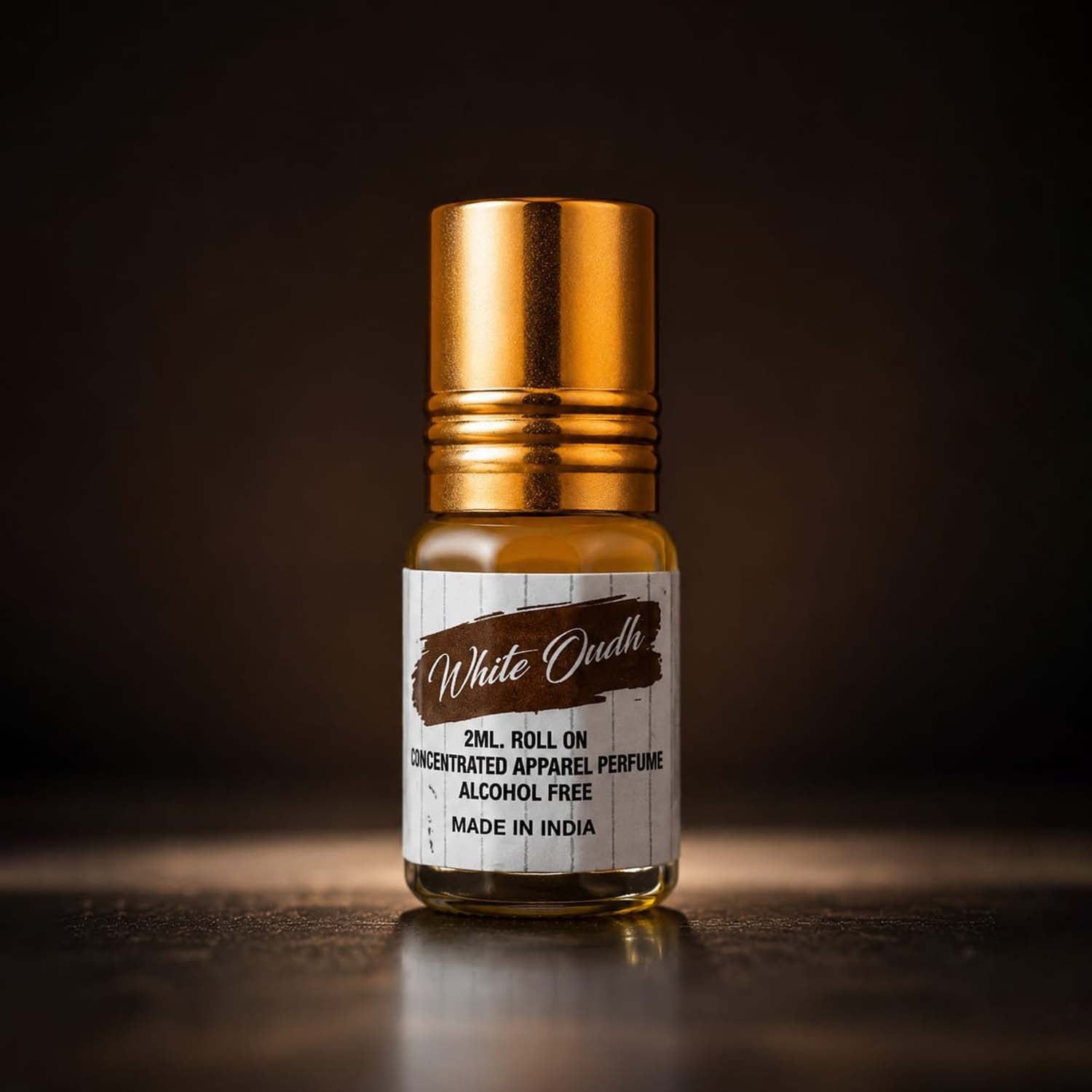 White Oudh 2ml concentrated apparel perfume roll-on glass bottle with a golden cap against a dark brown backdrop.