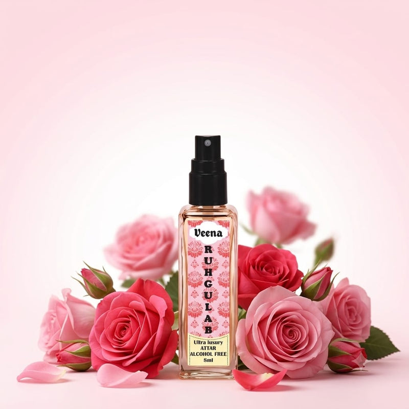 Veena Ruh Gulab Ultra Luxury Attar 8ml alcohol-free spray bottle centered amidst a beautiful cluster of fresh pink and red roses on a soft pink background.
