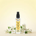 Veena Chameli Ultra Luxury Attar 8ml alcohol-free spray bottle centered amidst fresh white chameli jasmine flowers on a soft yellow background.