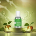 Veena Green Apple Fragrance for Candle Making bottle sitting on a round yellow display pedestal surrounded by white burning candles and fresh apples.
