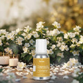 Veena Jasmine Fragrance for Candle Making bottle surrounded by scattered white jasmine petals and burning glass tea light candles under soft morning light.