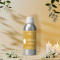 Veena Jasmine Fragrance for Candle Making aluminum bottle centered on a warm cream tabletop surrounded by glowing white candles and fresh jasmine blossoms. 